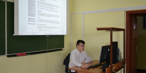 Uczeń siedzi przy komputerze, robi wykład o atakach sieciowych